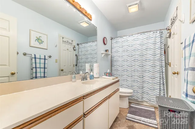 a bathroom with a sink a toilet and shower curtain