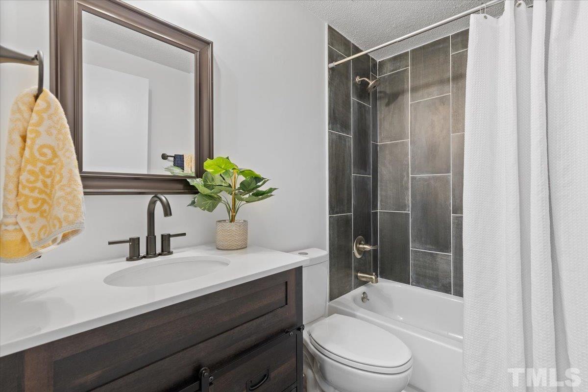 7721 Sandra Lane Raleigh, NC 27615 - Photo 28 of 29 a bathroom with a sink a toilet and shower