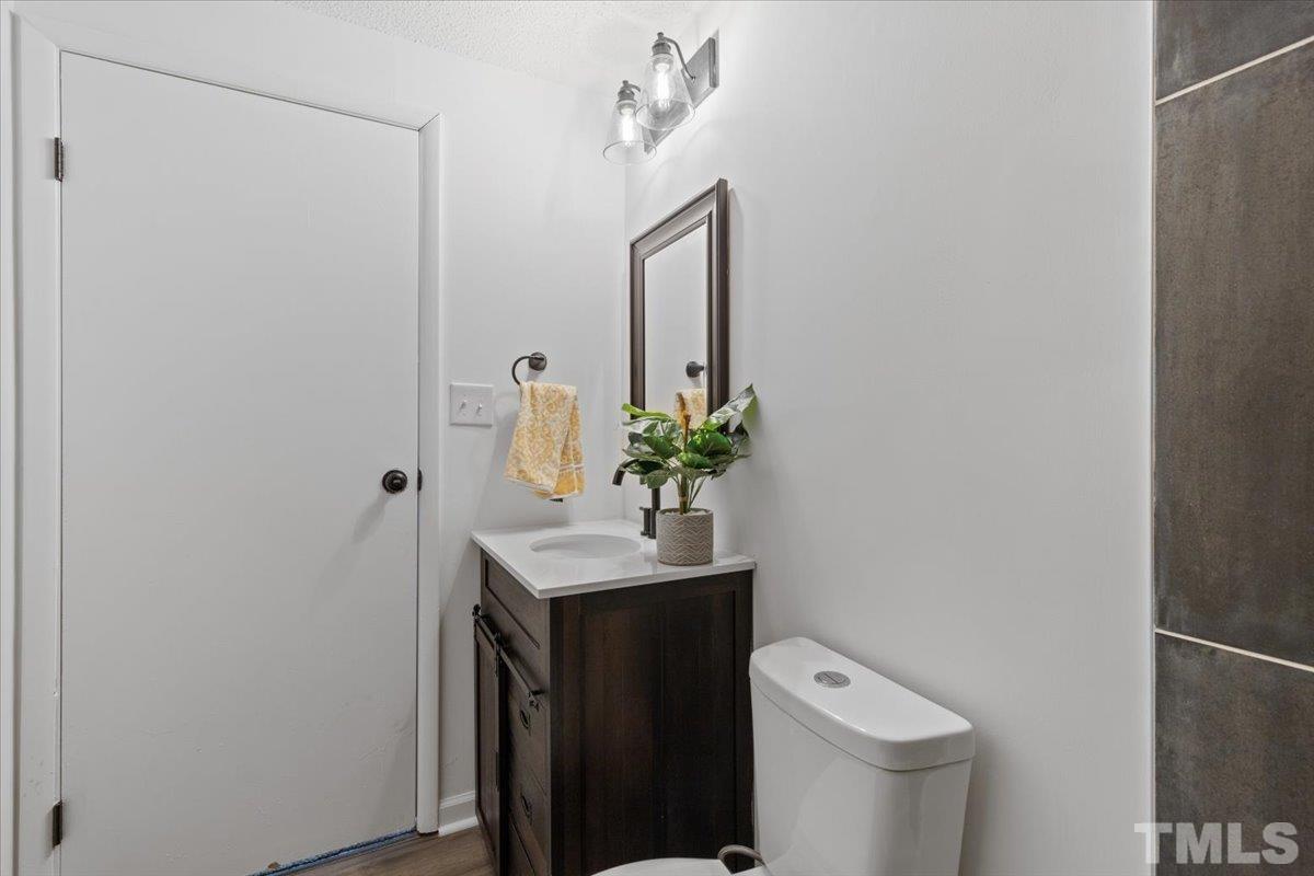 7721 Sandra Lane Raleigh, NC 27615 - Photo 29 of 29 a bathroom with a toilet a sink and mirror