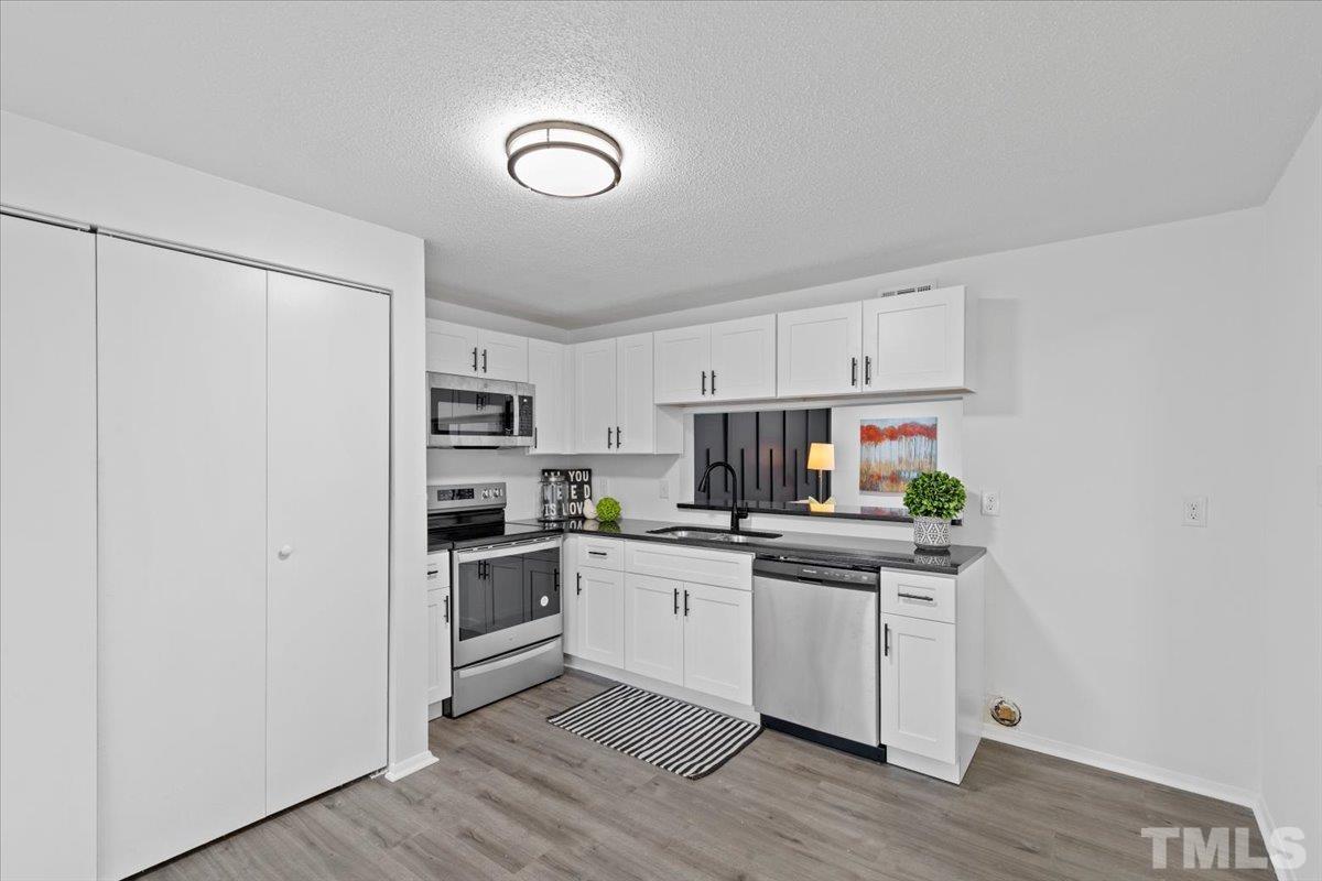 7721 Sandra Lane Raleigh, NC 27615 - Photo 6 of 29 a kitchen with stainless steel appliances a stove top oven and a refrigerator