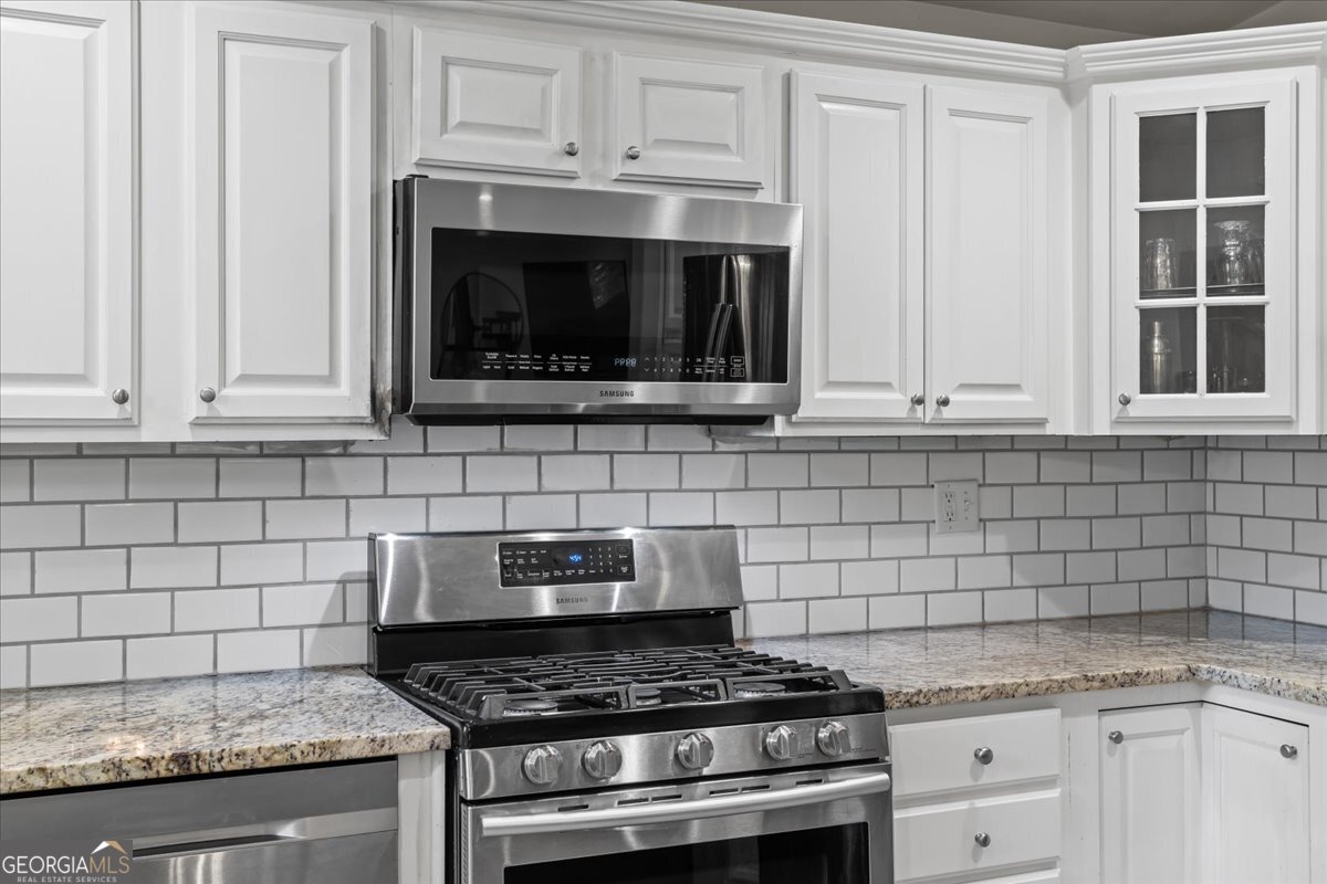 2316 Dorsey Avenue East Point, GA 30344 - Photo 13 of 25 a kitchen with granite countertop white cabinets and stainless steel appliances