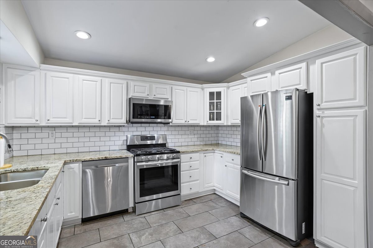 2316 Dorsey Avenue East Point, GA 30344 - Photo 15 of 25 a kitchen with white cabinets stainless steel appliances and a counter space