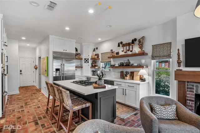 a kitchen with stainless steel appliances kitchen island granite countertop a stove a sink a refrigerator and a refrigerator