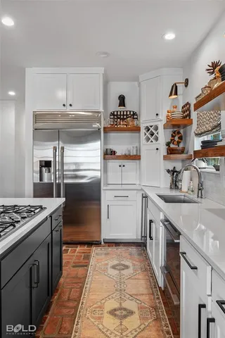 a kitchen with kitchen island stainless steel appliances a sink stove and cabinets