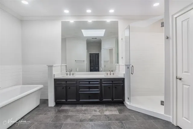 a spacious bathroom with a tub sink and mirror