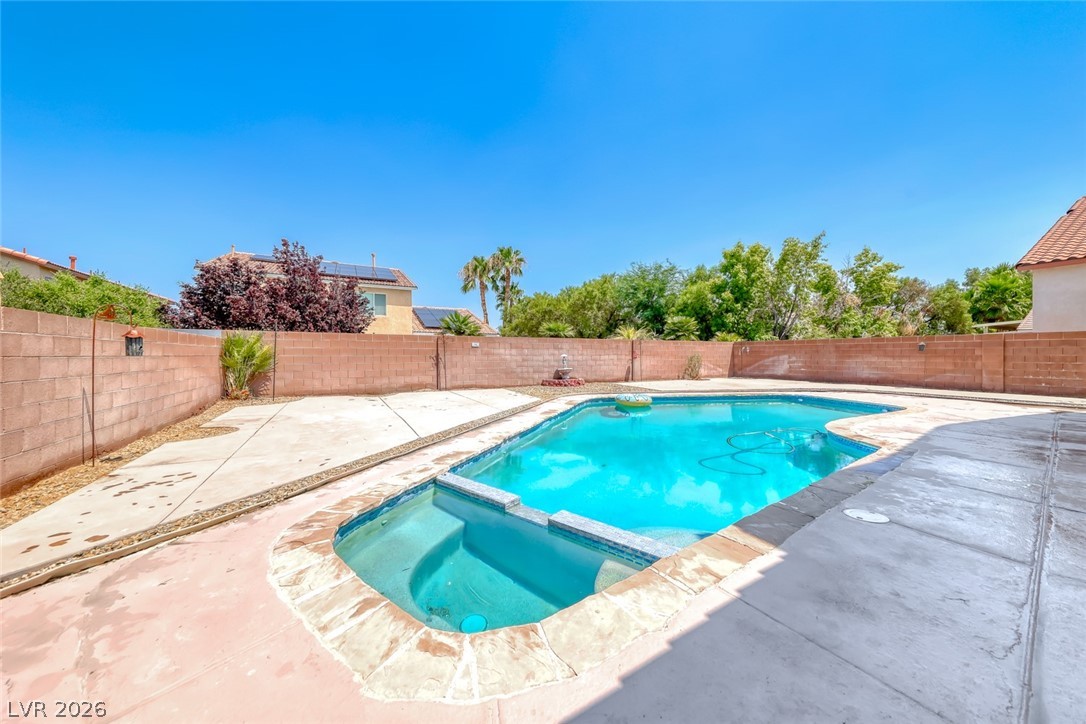 208 Glendon Street Henderson, NV 89074 - Photo 40 of 41 Cool Deck Recently Painterd (does not convey in this picture) An inviting backyard oasis features a glistening pool, perfect for sunny days and relaxation.