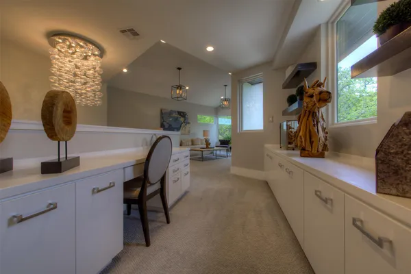 a kitchen with a refrigerator and white cabinets