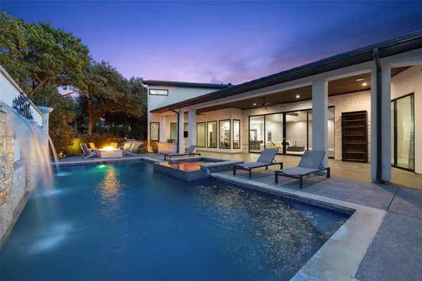 a view of a patio with swimming pool and sitting area