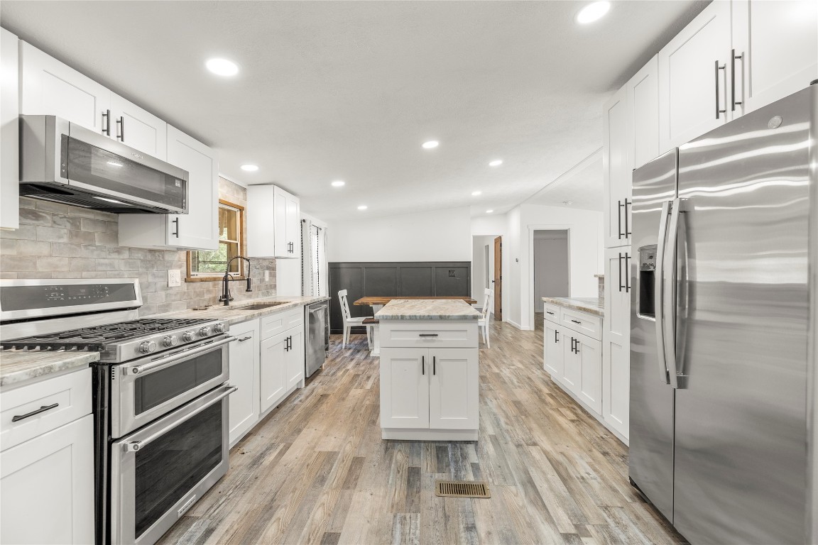 21150 Arnsworth Road Montgomery, TX 77356 - Photo 2 of 35 a kitchen with white cabinets and stainless steel appliances