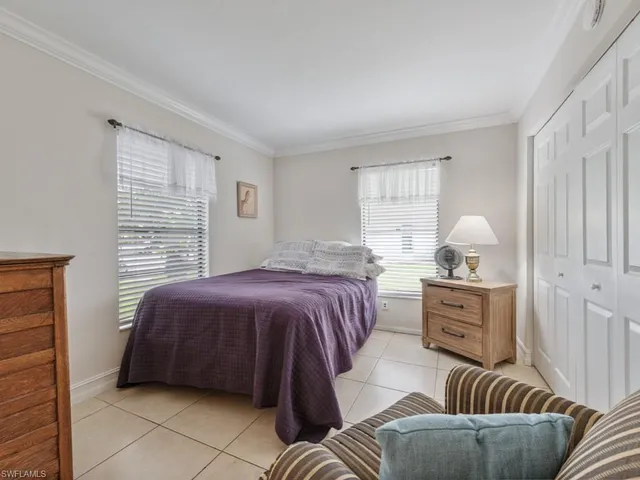 a bedroom with a bed and dresser with mirror