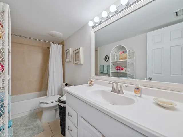 a bathroom with a sink a toilet and a large mirror