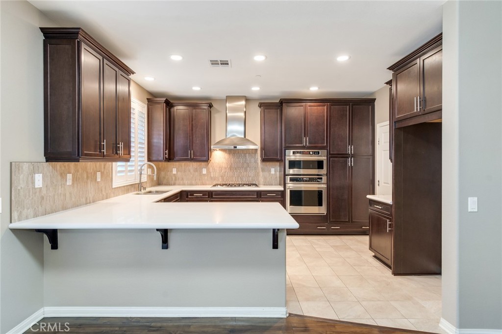 7903 Chaparral Drive Highland, CA 92346 - Photo 12 of 28 a large kitchen with stainless steel appliances kitchen island a large counter top and a refrigerator