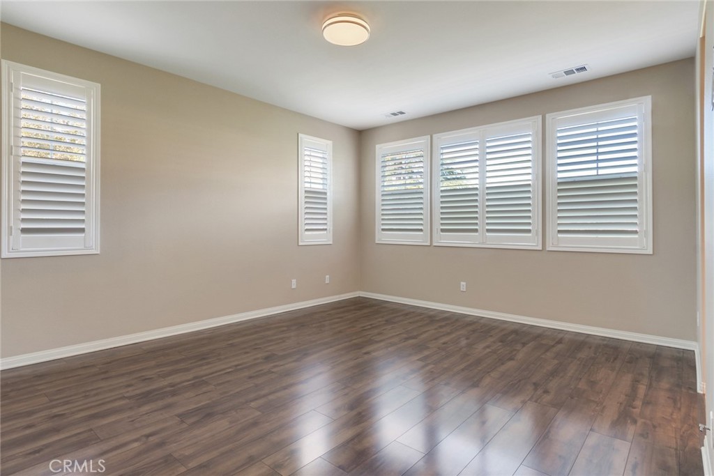 7903 Chaparral Drive Highland, CA 92346 - Photo 16 of 28 a view of an empty room with wooden floor and a window