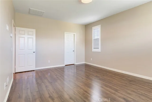 an empty room with wooden floor and window