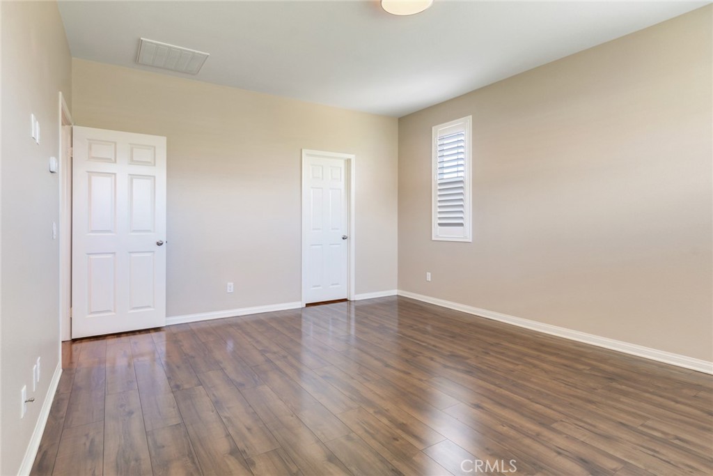 7903 Chaparral Drive Highland, CA 92346 - Photo 20 of 28 an empty room with wooden floor and window