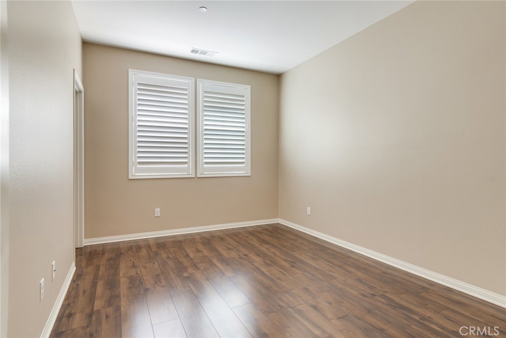 7903 Chaparral Drive Highland, CA 92346 - Photo 21 of 28 a view of an empty room with wooden floor and a window