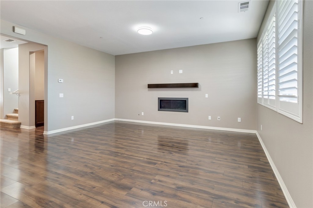 7903 Chaparral Drive Highland, CA 92346 - Photo 6 of 28 an empty room with wooden floor cabinet and windows
