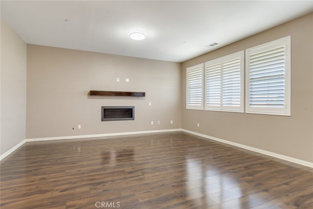 7903 Chaparral Drive Highland, CA 92346 - Photo 7 of 28 a view of an empty room with wooden floor and a window