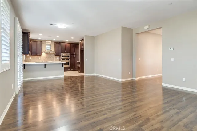 a view of a kitchen with wooden floor and a window