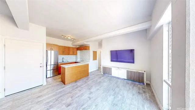 a large kitchen with a wooden floor and stainless steel appliances