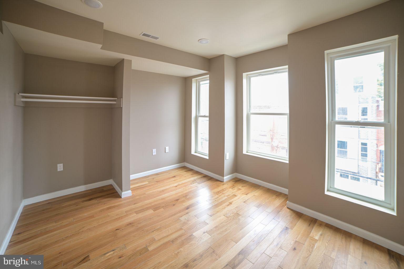 1806 Willington Street, Unit 2 Philadelphia, PA 19121 - Photo 4 of 16 a view of an empty room with wooden floor and a window