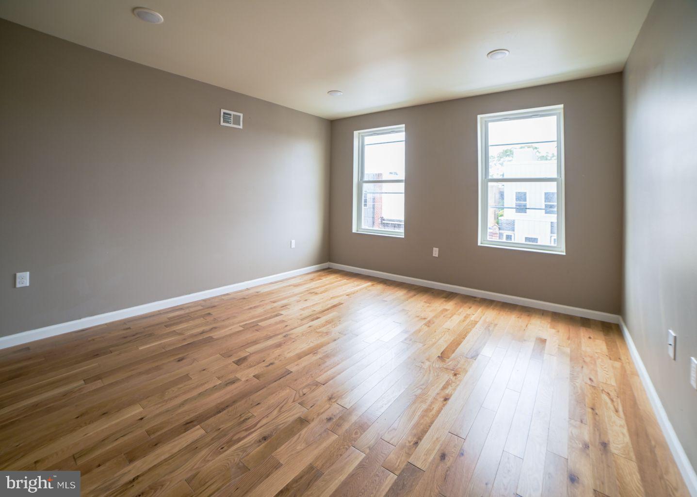 1806 Willington Street, Unit 2 Philadelphia, PA 19121 - Photo 6 of 16 an empty room with wooden floor and windows