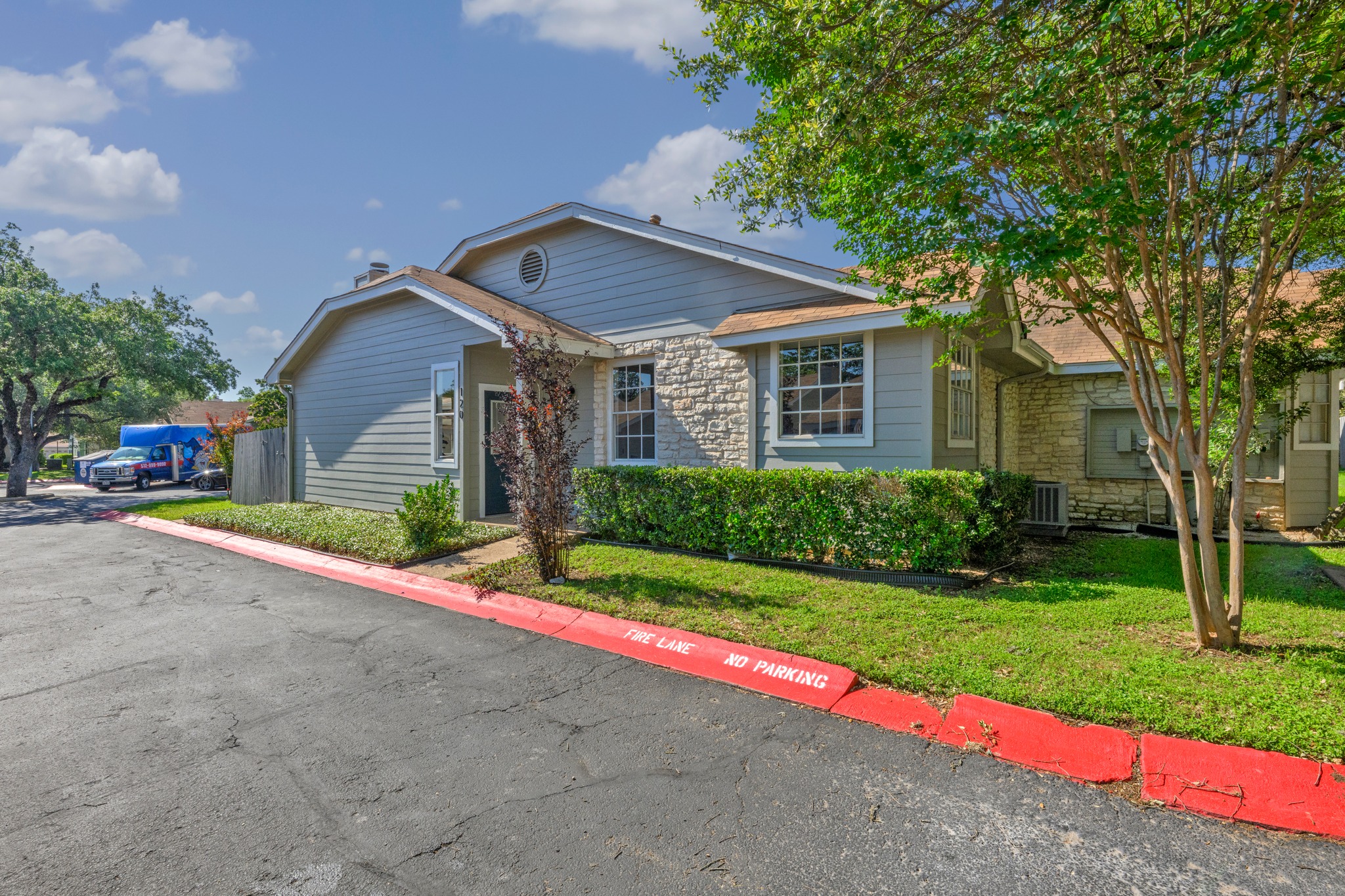 6501 Brush Country Road, Unit 120 Austin, TX 78749 - Photo 20 of 26 Exterior featuring a combination of horizontal siding and stone veneer, a low-pitch roof, and a prominent front entrance