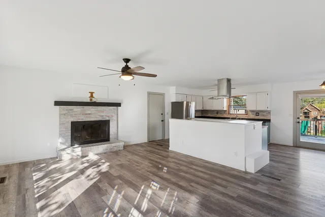 a kitchen with stainless steel appliances kitchen island a refrigerator sink and fireplace