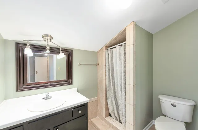 a bathroom with a sink a toilet and a mirror