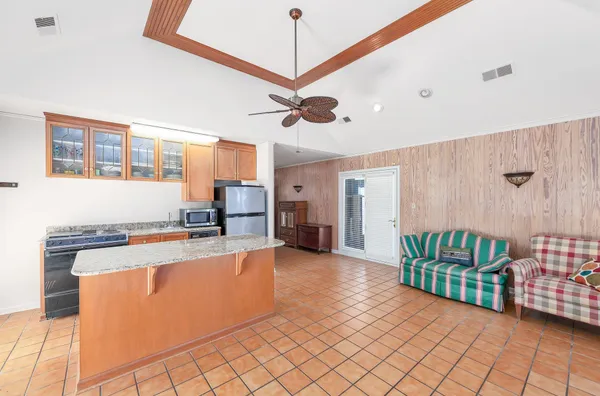 a kitchen with granite countertop a stove a sink and a refrigerator