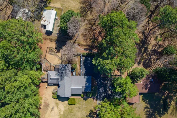 an aerial view of a house with a yard and fountain in middle