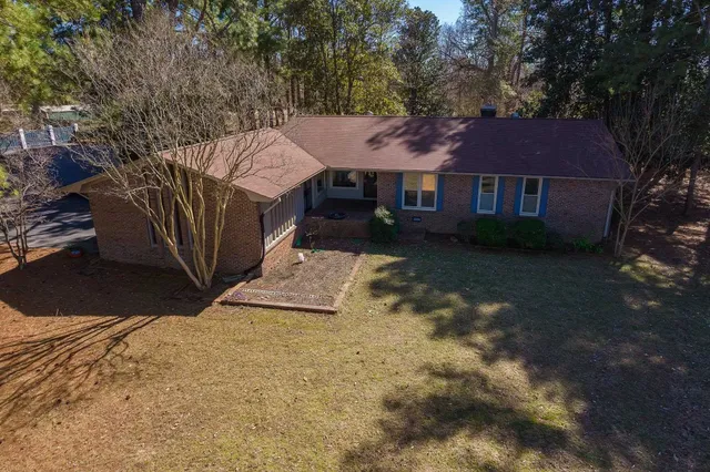 a view of a yard in front of a house with large tree