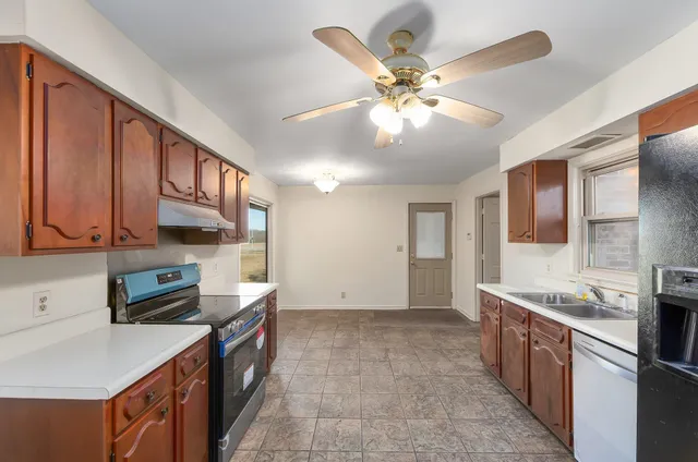 a kitchen with stainless steel appliances granite countertop a sink stove and refrigerator