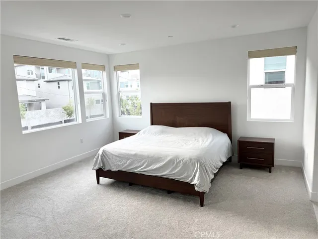 a bed sitting in a bedroom next to a window