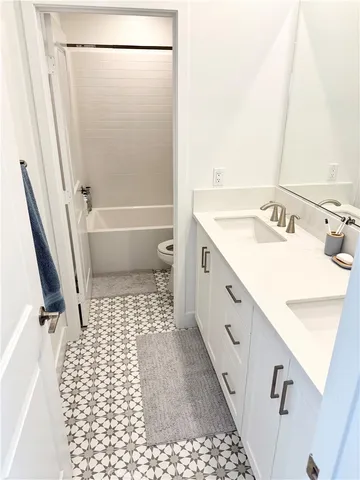 a bathroom with a sink a toilet a mirror and shower