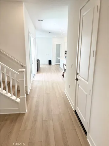 a view of a bedroom with a bed and wooden floor