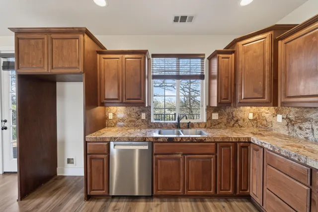 a kitchen with stainless steel appliances granite countertop a sink stove and cabinets