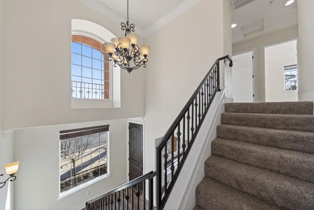 a view of staircase with wooden floor and chandelier