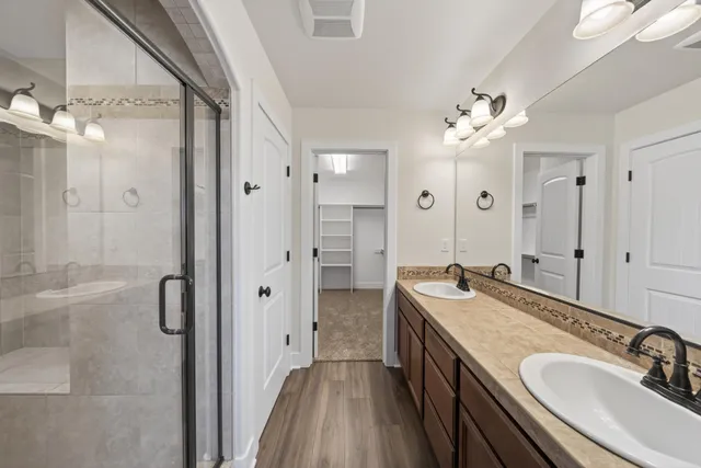 a bathroom with a granite countertop sink a large mirror and a shower