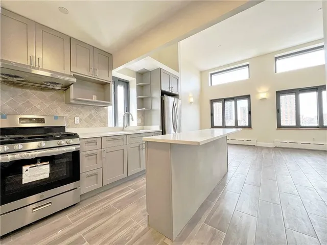a kitchen with stainless steel appliances a stove a sink and cabinets