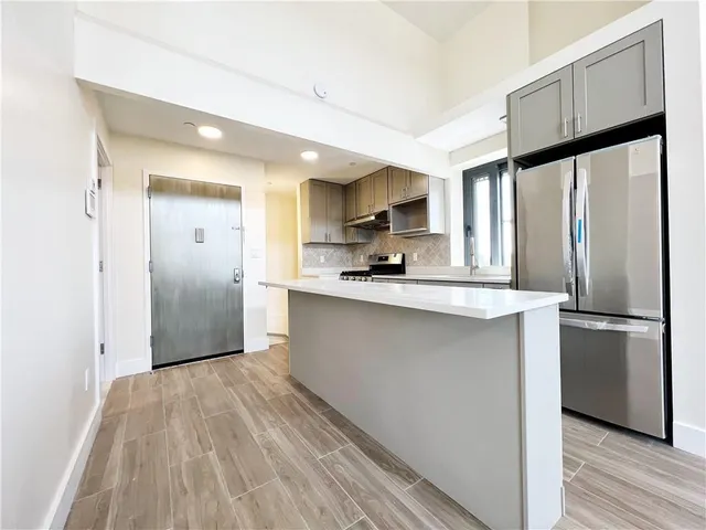 a kitchen with stainless steel appliances a refrigerator sink and microwave