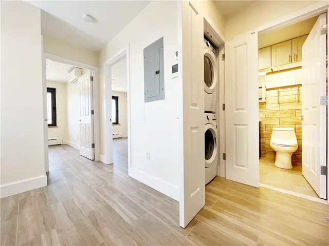 a view of a hallway with wooden floor and bathroom