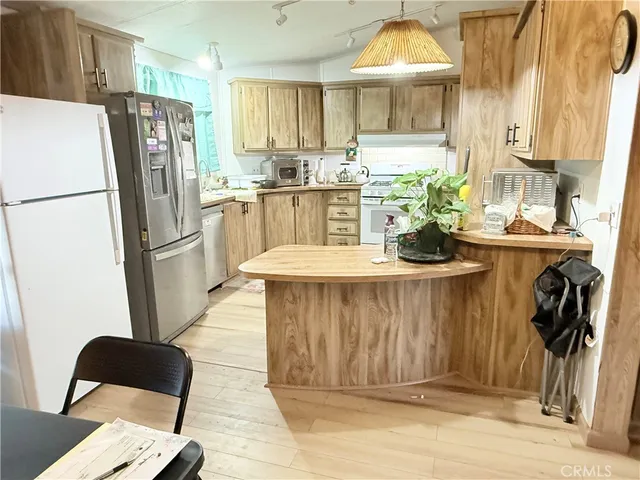 a kitchen with stainless steel appliances granite countertop a refrigerator and a sink