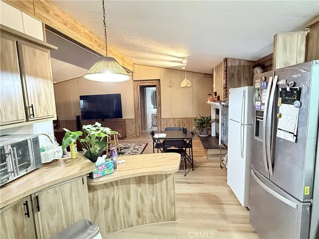 a kitchen with a refrigerator a sink dishwasher and a stove with wooden floor