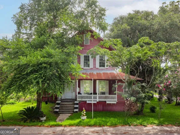 a front view of a house with a garden