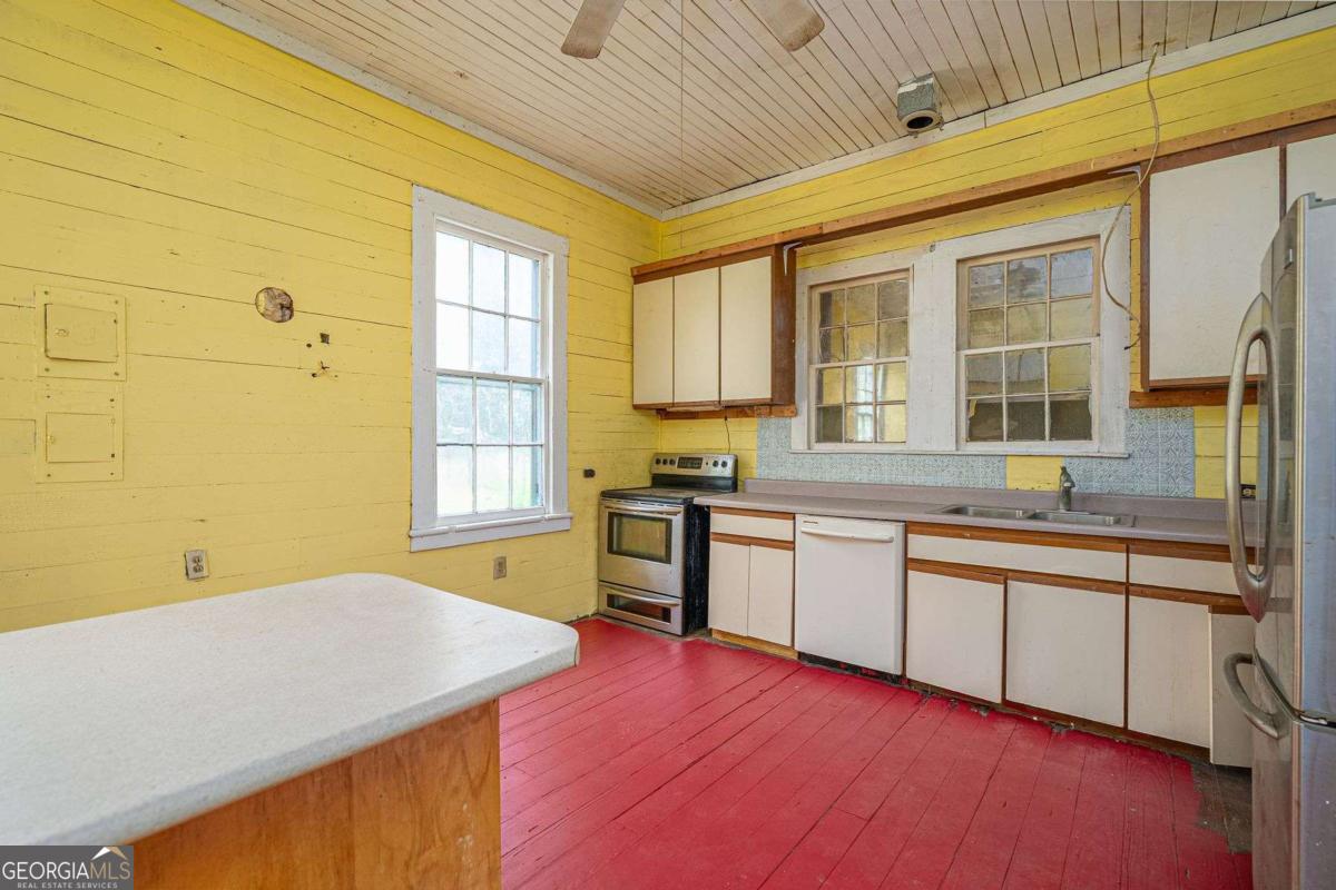 602 Magnolia Street Guyton, GA 31312 - Photo 12 of 34 a kitchen with stainless steel appliances granite countertop a sink and cabinets with wooden floor