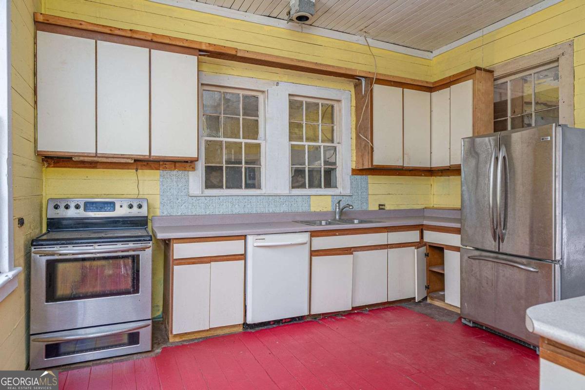 602 Magnolia Street Guyton, GA 31312 - Photo 13 of 34 a kitchen with stainless steel appliances granite countertop a stove and a refrigerator