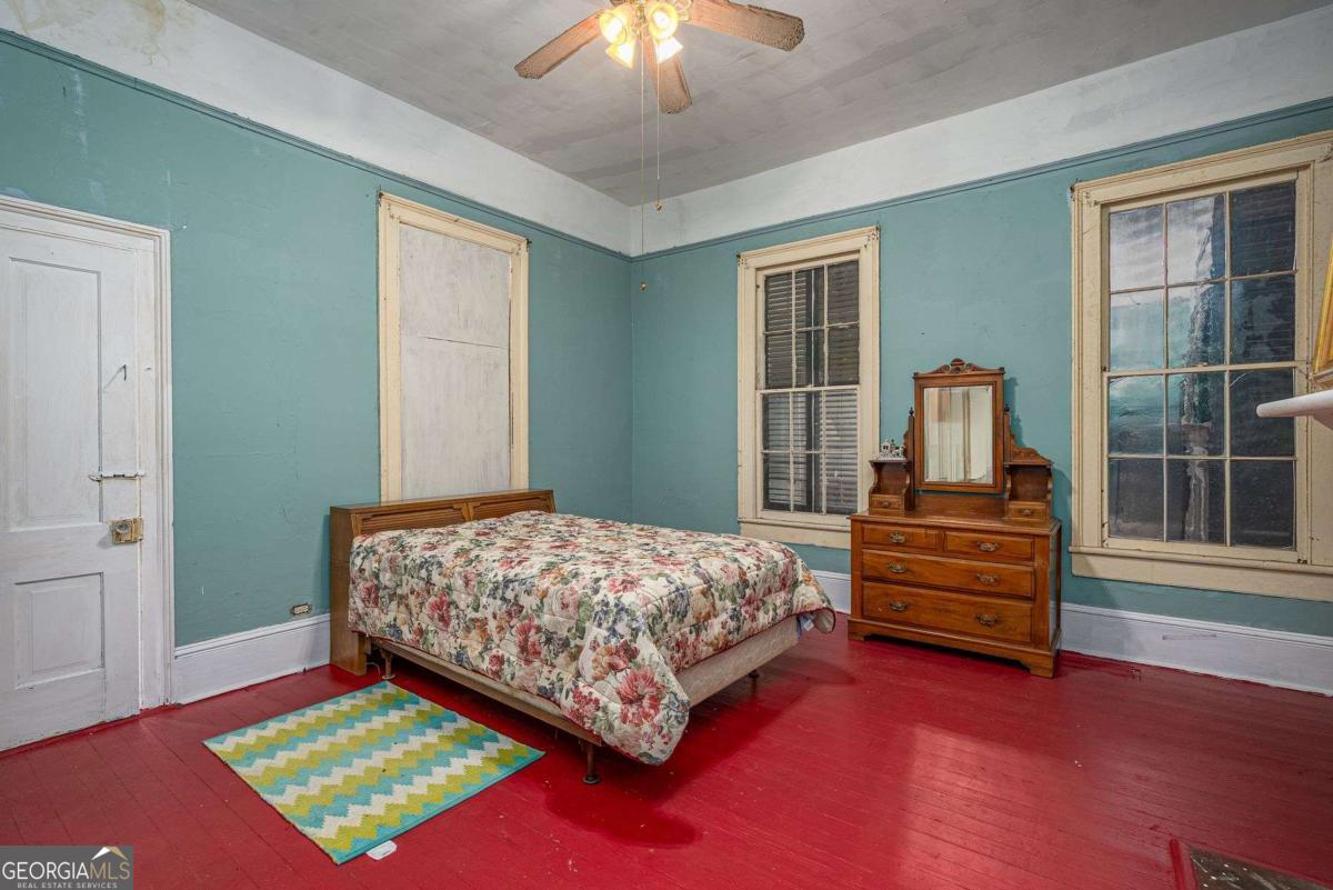 602 Magnolia Street Guyton, GA 31312 - Photo 16 of 34 a bedroom with a bed and a chandelier next to a window