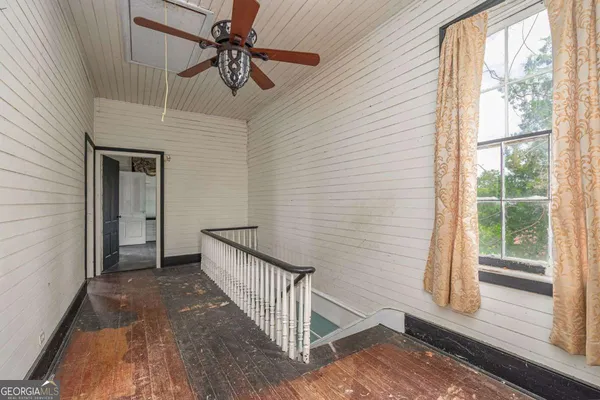 a view of a livingroom with a ceiling fan and a hardwood floor