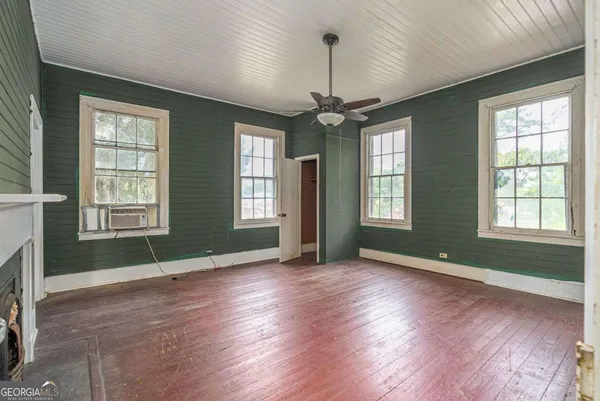 a view of empty room with fireplace and wooden floor